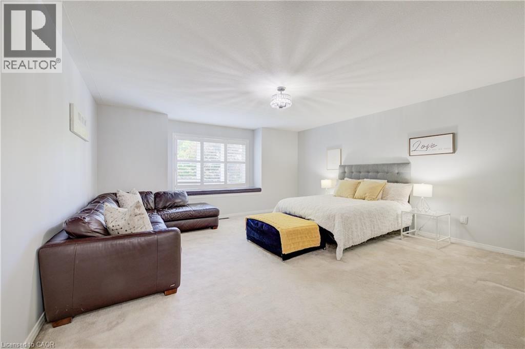 Spacious interior room featuring light-colored carpet flooring, white walls, and a window with white plantation shutters - 23 Buerkle Court, Kitchener, ON - Indoor Photo Showing Bedroom