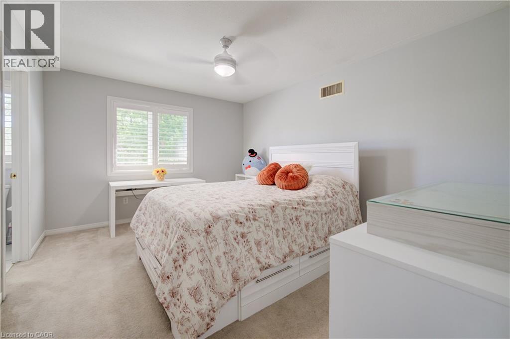 Bedroom featuring light gray wall paint, neutral carpet flooring, and a white ceiling fan with integrated lighting - 23 Buerkle Court, Kitchener, ON - Indoor Photo Showing Bedroom