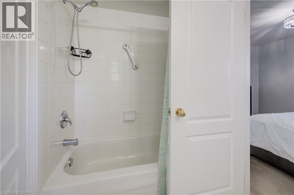 Bathtub with white subway tile surround, chrome fixtures, and a handheld showerhead - 23 Buerkle Court, Kitchener, ON - Indoor Photo Showing Bathroom