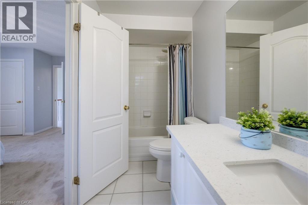 Bathroom featuring a white vanity with a light-colored countertop, integrated sink, and white cabinetry - 23 Buerkle Court, Kitchener, ON - Indoor Photo Showing Bathroom