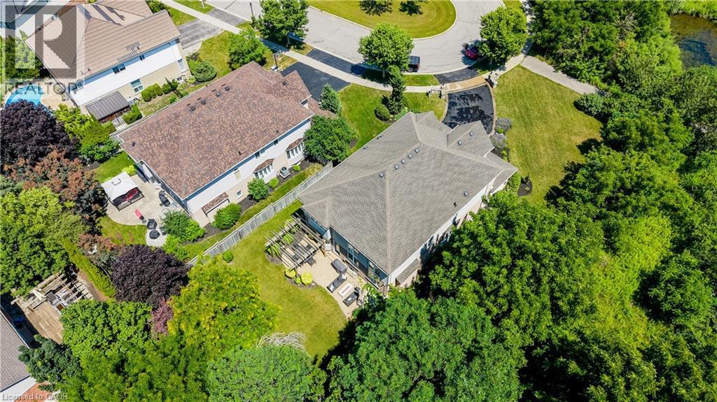 Aerial perspective showcasing a property featuring a dark shingle roof, light-colored siding, and a paved driveway leading to a two-car garage - 23 Buerkle Court, Kitchener, ON - Outdoor With View
