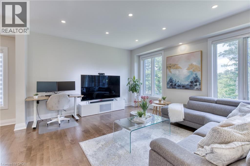Bright interior space featuring recessed ceiling lighting, wood-finish flooring, and multiple large windows - 71 Ian Ormston Drive, Waterloo, ON
