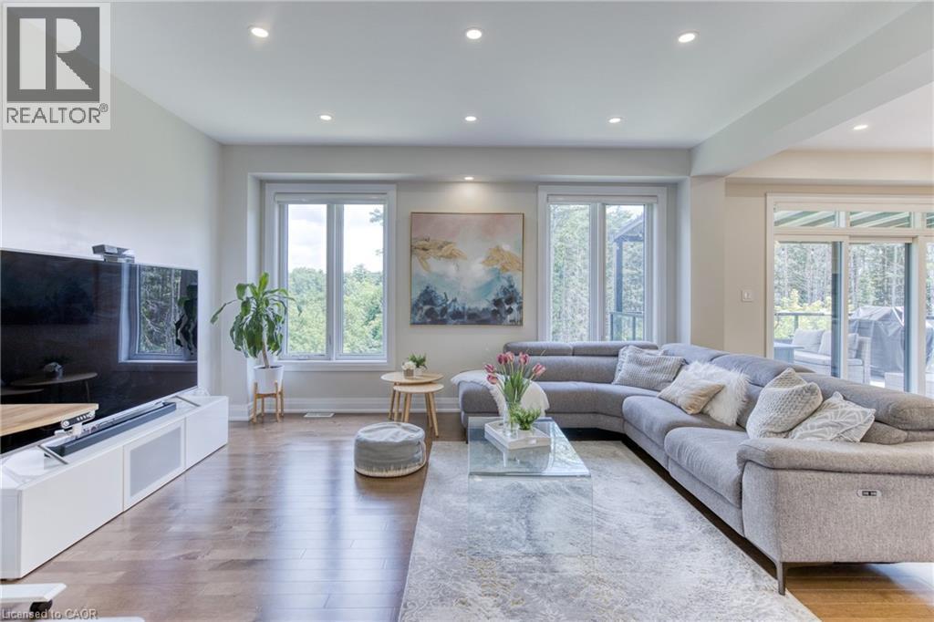 Open-concept living space featuring wood-finish flooring, recessed lighting, and multiple large windows - 71 Ian Ormston Drive, Waterloo, ON