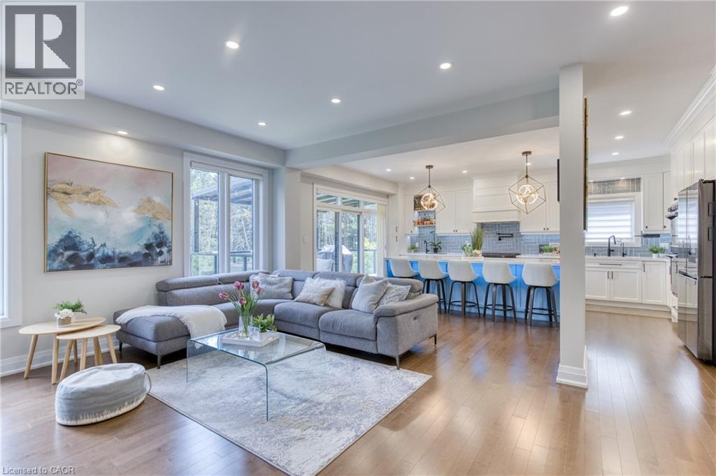 Open-concept living space featuring wood-finish flooring, recessed lighting, and large windows - 71 Ian Ormston Drive, Waterloo, ON