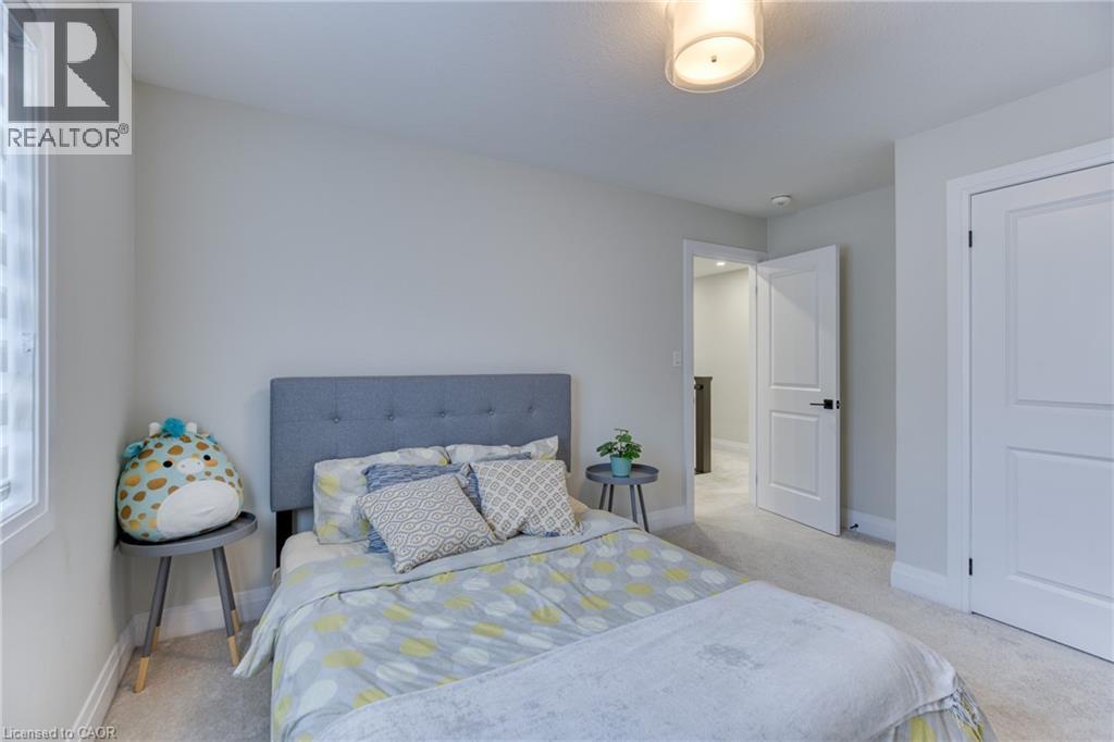 Carpeted room featuring light gray walls, a window with vertical blinds, and a white interior door with black hardware - 71 Ian Ormston Drive, Waterloo, ON