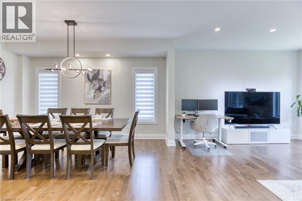 Open-concept interior featuring wood-finish flooring, recessed lighting, and a modern linear chandelier - 71 Ian Ormston Drive, Kitchener, ON - Indoor Photo Showing Dining Room