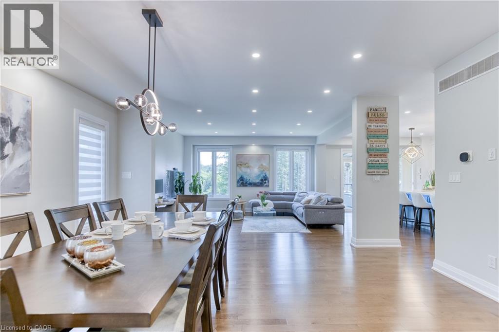 Open-concept living area featuring wood-finish flooring, recessed lighting, and a modern chandelier - 71 Ian Ormston Drive, Waterloo, ON