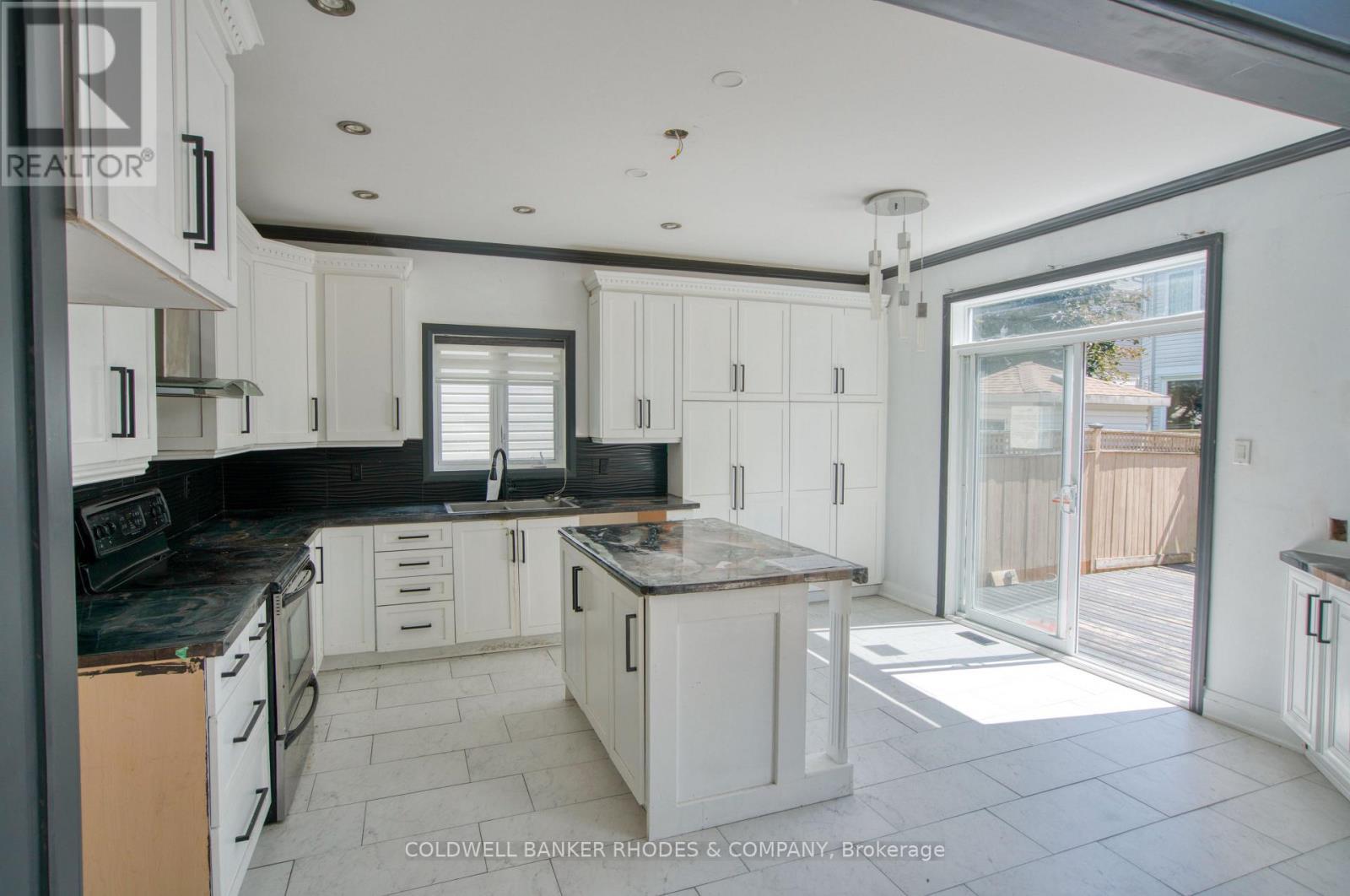 Bright open kitchen leads to backyard. - 32 Catterick Crescent, Ottawa, ON