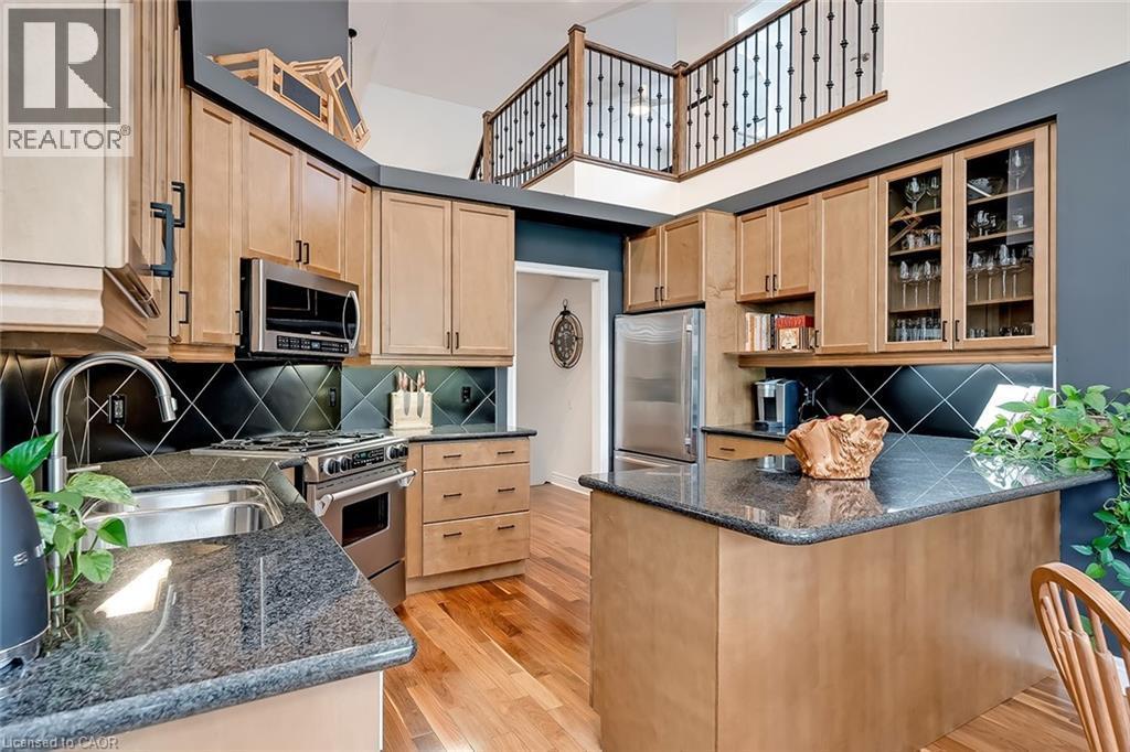 Kitchen is tucked in behind the fireplace - 4285 Couples Crescent, Burlington, ON - Indoor Photo Showing Kitchen With Double Sink With Upgraded Kitchen