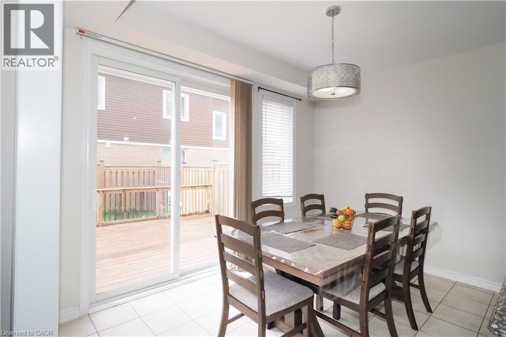 Dining area featuring tile flooring, a drum pendant light fixture, and white walls - 213 Seabrook Drive, Kitchener, ON