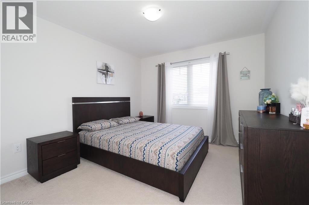 Bright sleeping area featuring neutral carpeting and white wall finishes - 213 Seabrook Drive, Kitchener, ON