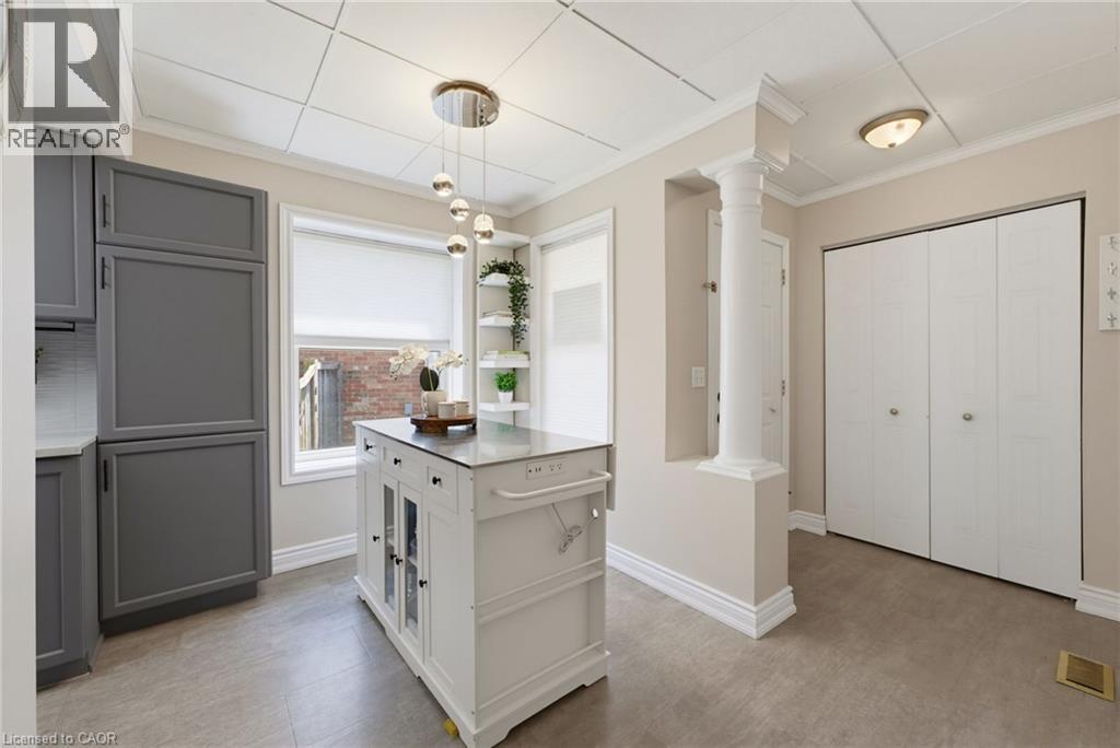Kitchen featuring a central island, grey cabinetry, a window with roller shade, built-in shelving, and recessed lighting - 520 Mayflower Street, Waterloo, ON - Indoor