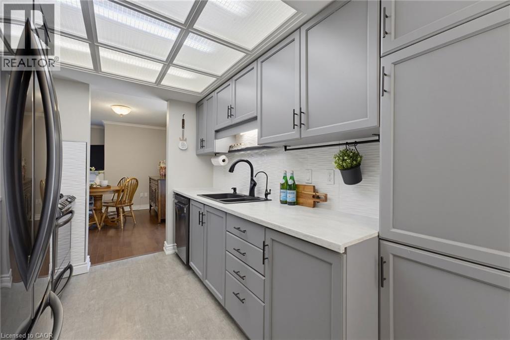Modern kitchen featuring gray cabinetry with matte black hardware, white countertops, and a subway tile backsplash - 520 Mayflower Street, Waterloo, ON - Indoor Photo Showing Kitchen With Double Sink