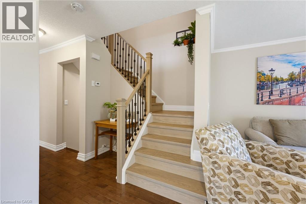 Staircase featuring wood-finish treads and risers, black metal balusters, and a light-toned wood-finish handrail - 520 Mayflower Street, Waterloo, ON - Indoor Photo Showing Other Room