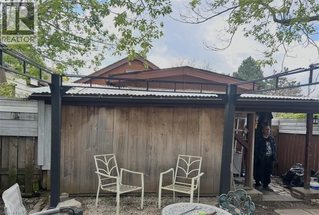 covered porch and fenced yard with 2 storage sheds - 456 Jackson Street W, Hamilton, ON - Outdoor