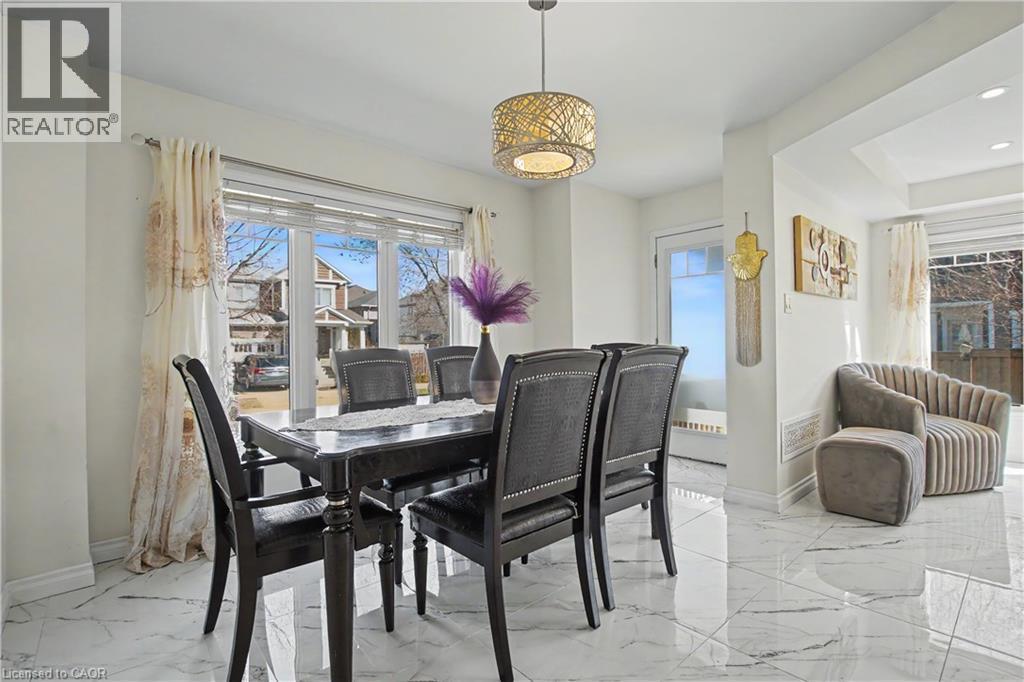 Bright dining area featuring large windows, white walls, marble-finish flooring, a contemporary ceiling fixture, and a tray ceiling detail - 60 Postmaster Drive, Kitchener, ON - Indoor Photo Showing Dining Room