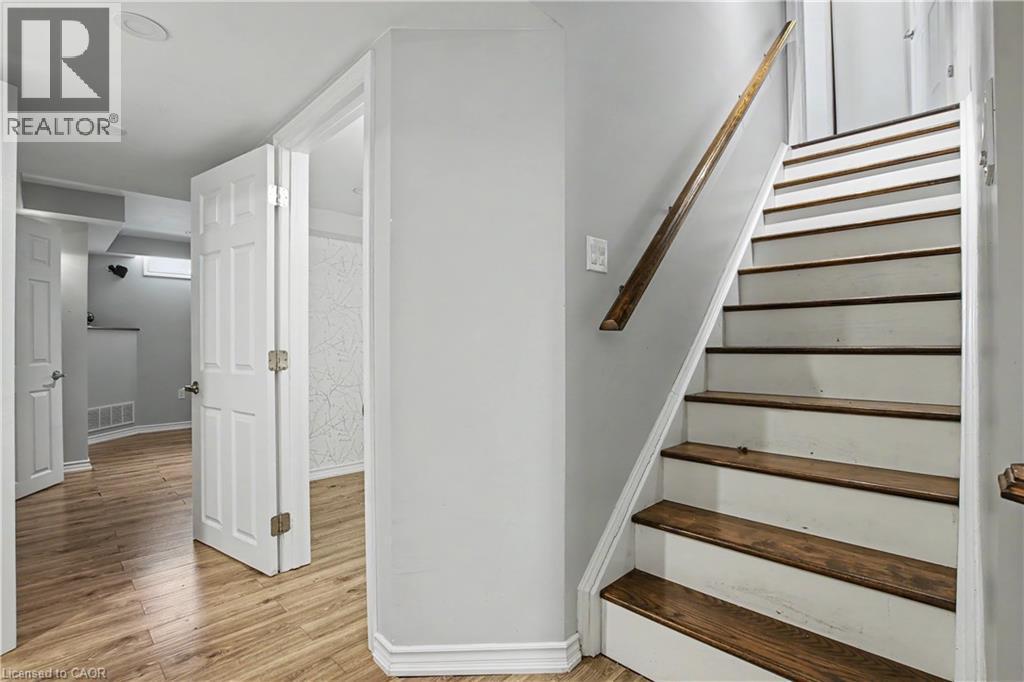 Interior staircase featuring wood-finish treads and a coordinating wood handrail - 60 Postmaster Drive, Kitchener, ON - Indoor Photo Showing Other Room
