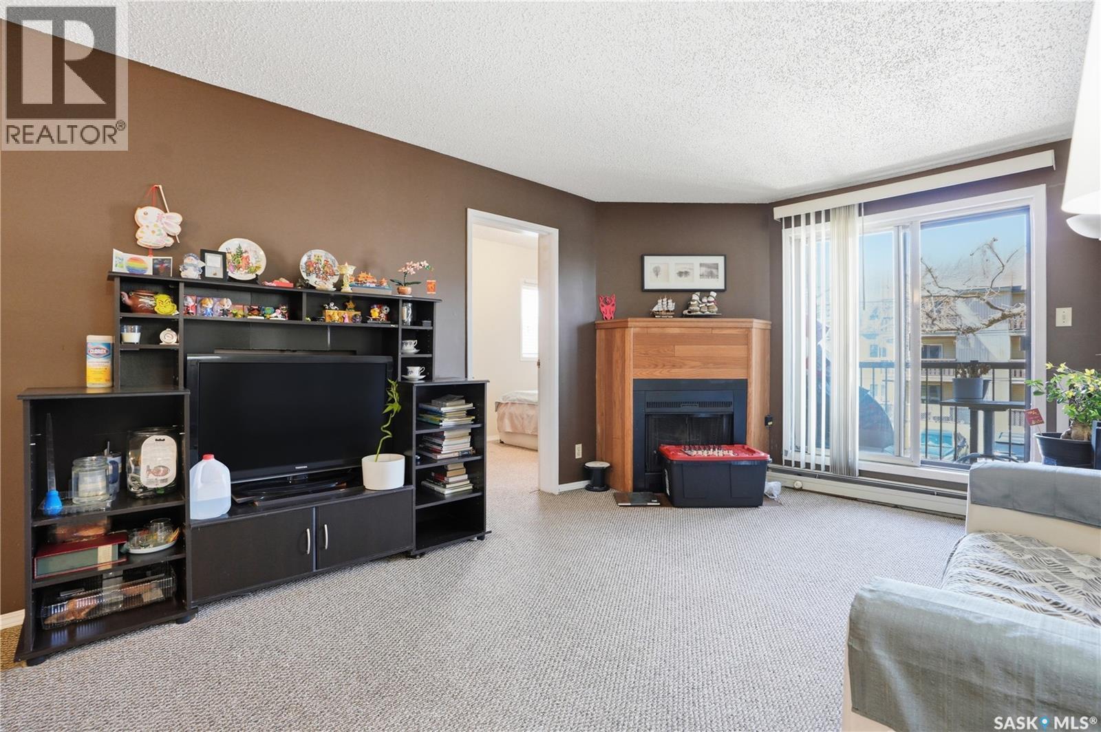 214A 4040 8Th Street E, Saskatoon, SK - Indoor Photo Showing Living Room With Fireplace