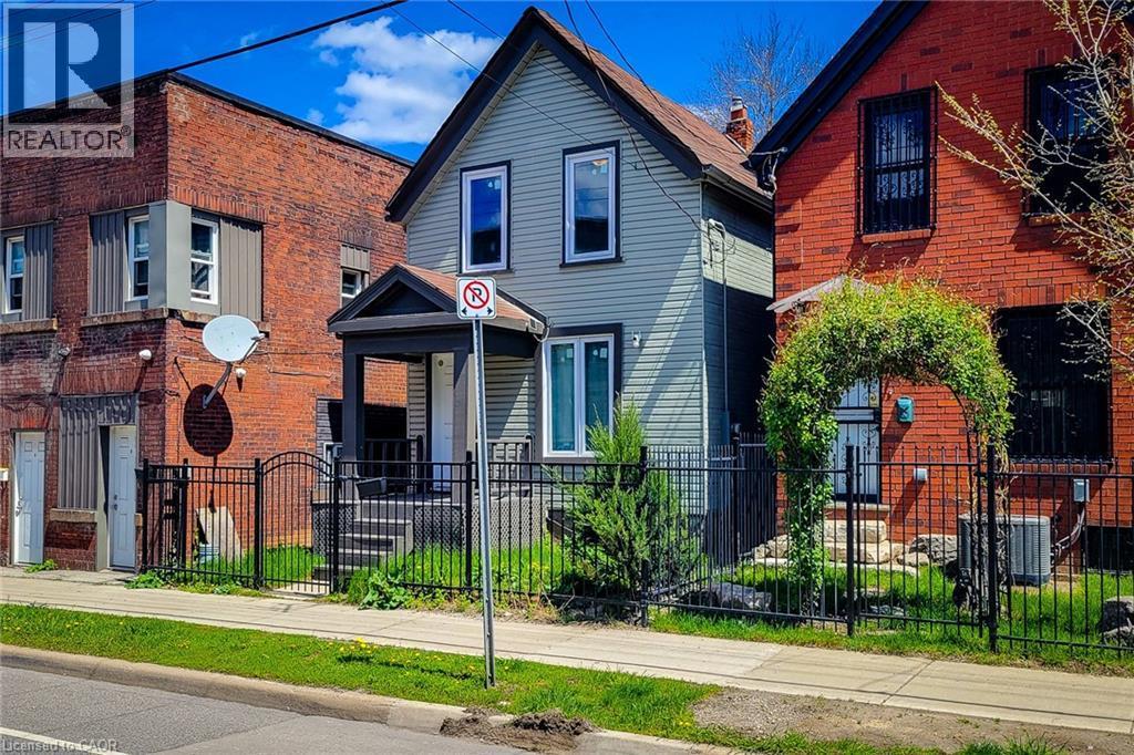Gabled facade with light-toned siding, black trim, and a covered front porch entry - 334 Gage Avenue N, Hamilton, ON - Outdoor With Facade