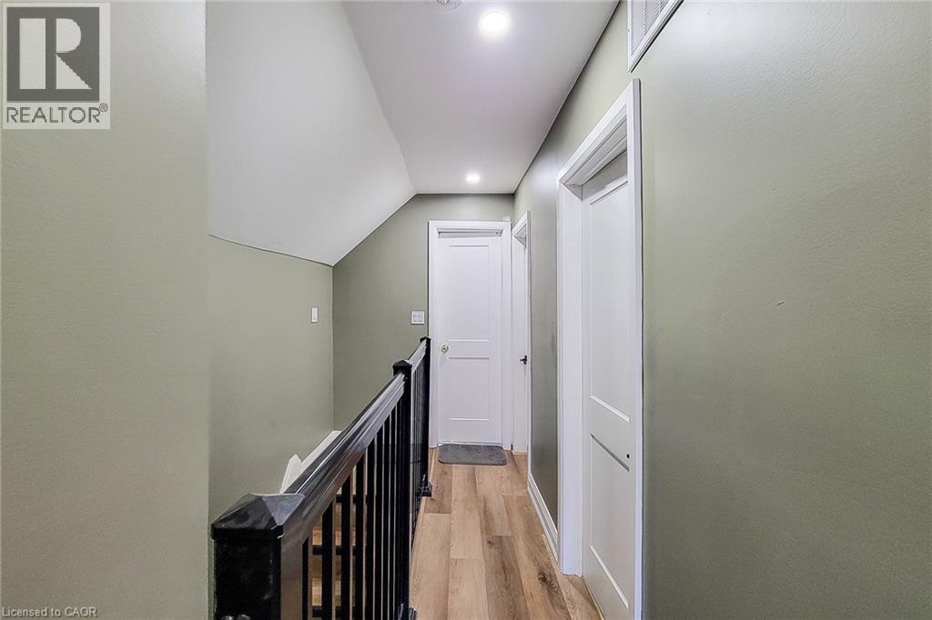 Hallway featuring wood-finish flooring, recessed lighting, and a black balustrade - 334 Gage Avenue N, Hamilton, ON - Indoor Photo Showing Other Room