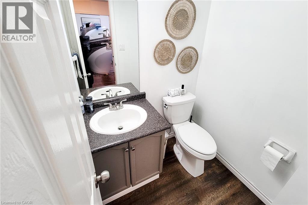 Bathroom featuring a vanity with an integrated sink, dark speckled countertop, and under-sink cabinetry - 7 Davidson Boulevard Unit# 14, Dundas, ON - Indoor Photo Showing Bathroom