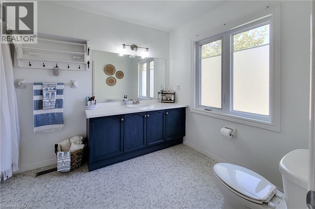 Bathroom featuring a dual-sink vanity with a dark blue cabinet base and white countertop - 7 Davidson Boulevard Unit# 14, Dundas, ON - Indoor Photo Showing Bathroom