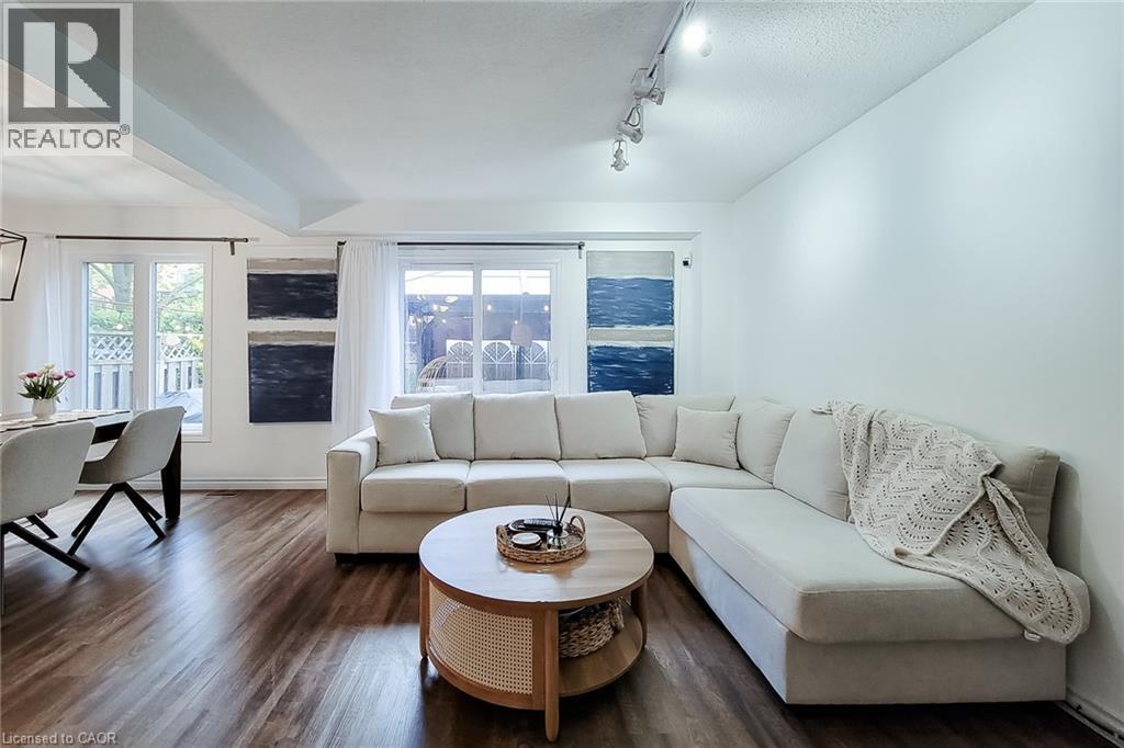 Living area featuring dark wood-finish flooring, white walls, and a recessed ceiling element - 7 Davidson Boulevard Unit# 14, Dundas, ON - Indoor Photo Showing Living Room