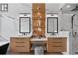 Luxurious 5-piece primary ensuite featuring heated tile floors, a soaker tub, dual vanities, and a spacious tile shower for a true spa-like experience. -