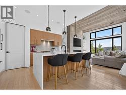 Chef-inspired kitchen featuring a waterfall island, KitchenAid appliances, wine fridge, 6-burner gas range, and abundant storage for effortless entertaining. -