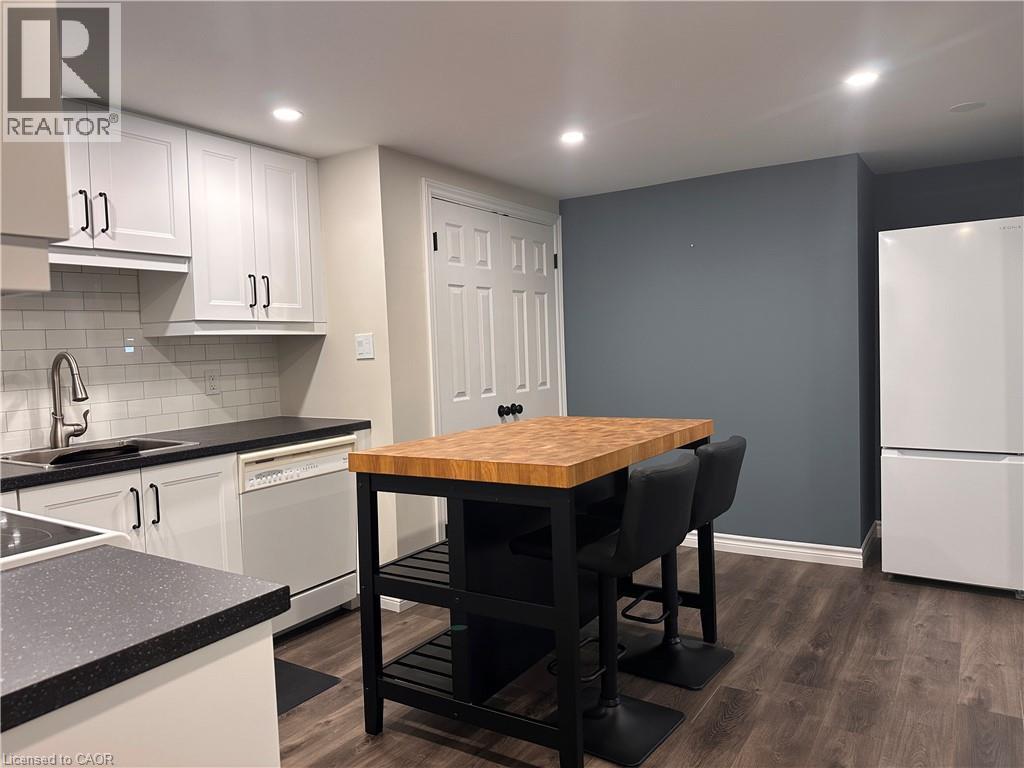Kitchen featuring white cabinetry with dark hardware, dark countertops, and a subway tile backsplash - 4187 Weimar Line, Wellesley, ON - Indoor