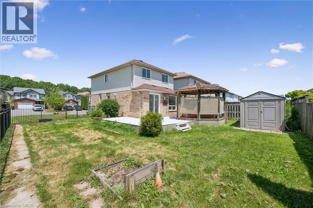 Expansive backyard featuring a gazebo with privacy panels, a dedicated storage shed, a ground-level deck, and a raised planter box - 71 Peach Blossom Crescent, Kitchener, ON - Outdoor