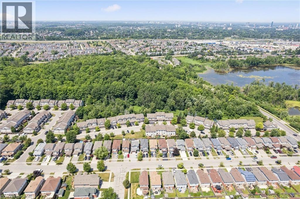 Aerial perspective showcasing a residential community bordered by mature trees and a natural water feature - 71 Peach Blossom Crescent, Kitchener, ON - Outdoor With View