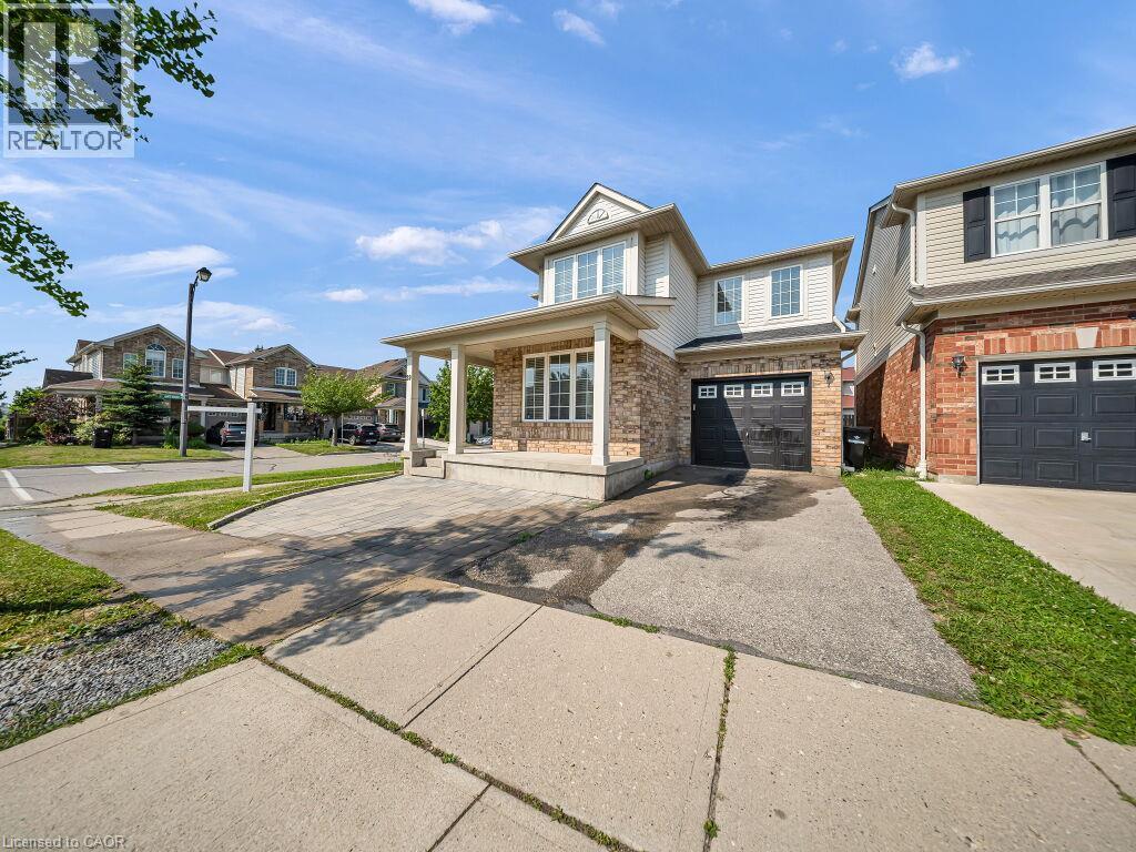 Two-story brick and siding residence featuring a covered front porch, an attached single-car garage, and a concrete driveway - 39 Baintree Way, Cambridge, ON - Outdoor With Facade