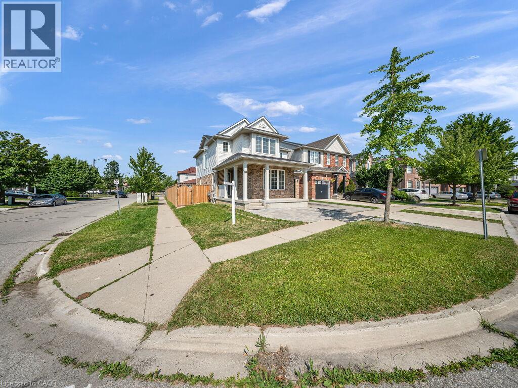 Two-story residence featuring a brick and siding exterior, a covered front porch with white pillars, and a paved driveway - 39 Baintree Way, Cambridge, ON - Outdoor