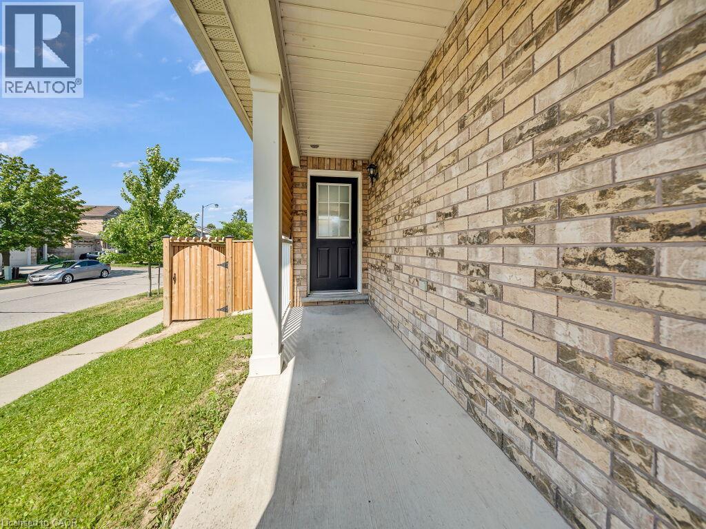 Front porch entryway featuring a multi-toned brick facade and a dark-paneled door with glass insert - 39 Baintree Way, Cambridge, ON - Outdoor