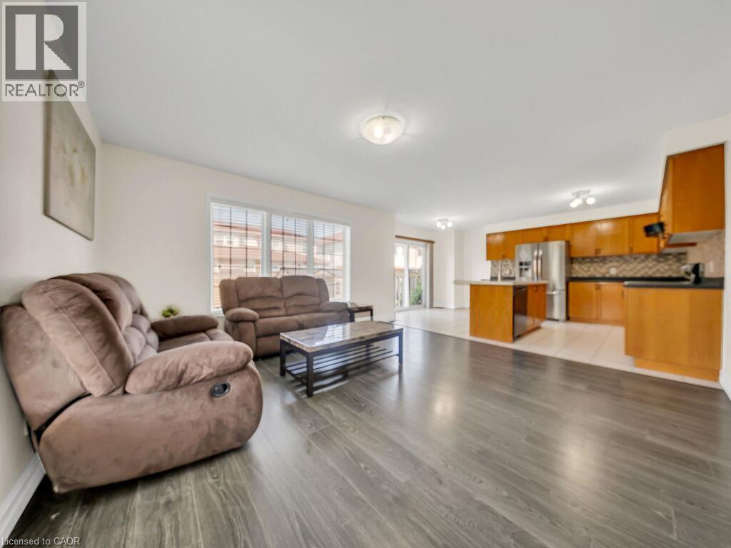Open-concept living space featuring wood-finish flooring, white wall paint, and recessed lighting - 39 Baintree Way, Cambridge, ON - Indoor Photo Showing Living Room
