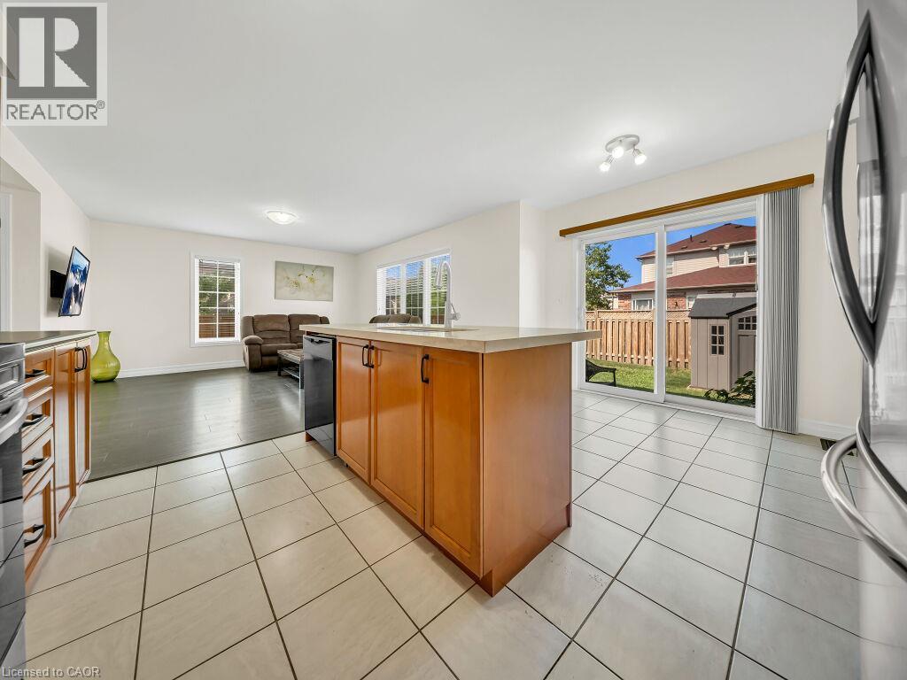 Kitchen island featuring wood cabinetry and a neutral countertop - 39 Baintree Way, Cambridge, ON - Indoor Photo Showing Kitchen
