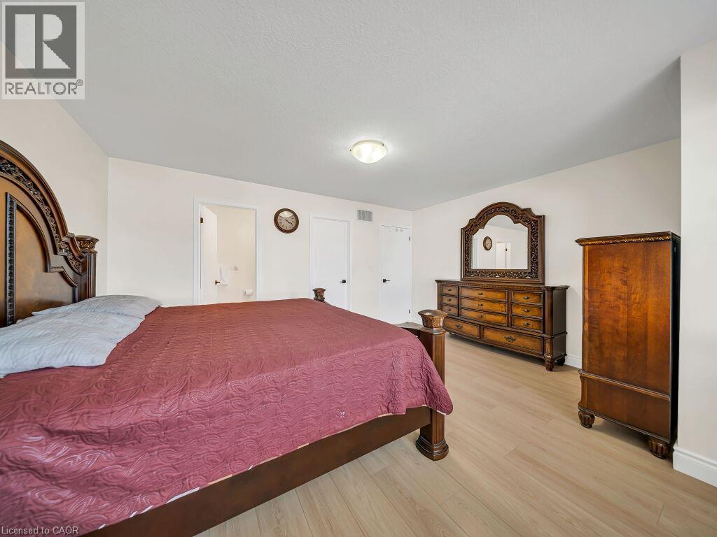 Light wood-finish flooring complements the neutral wall color in this room - 39 Baintree Way, Cambridge, ON - Indoor Photo Showing Bedroom