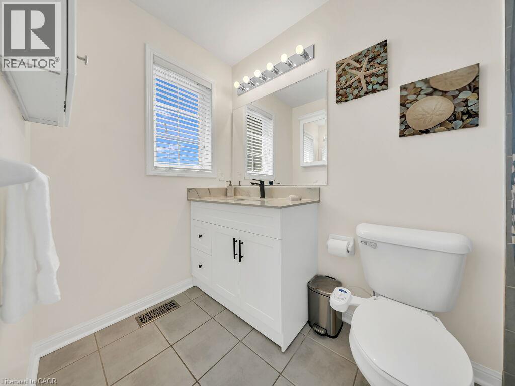 Bathroom featuring a white vanity with a light-toned countertop, a window with blinds, and tiled flooring - 39 Baintree Way, Cambridge, ON - Indoor Photo Showing Bathroom
