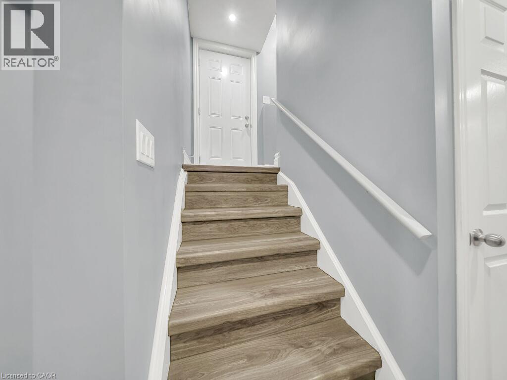Staircase featuring wood-finish treads, a white handrail, and light gray wall paint - 39 Baintree Way, Cambridge, ON - Indoor Photo Showing Other Room