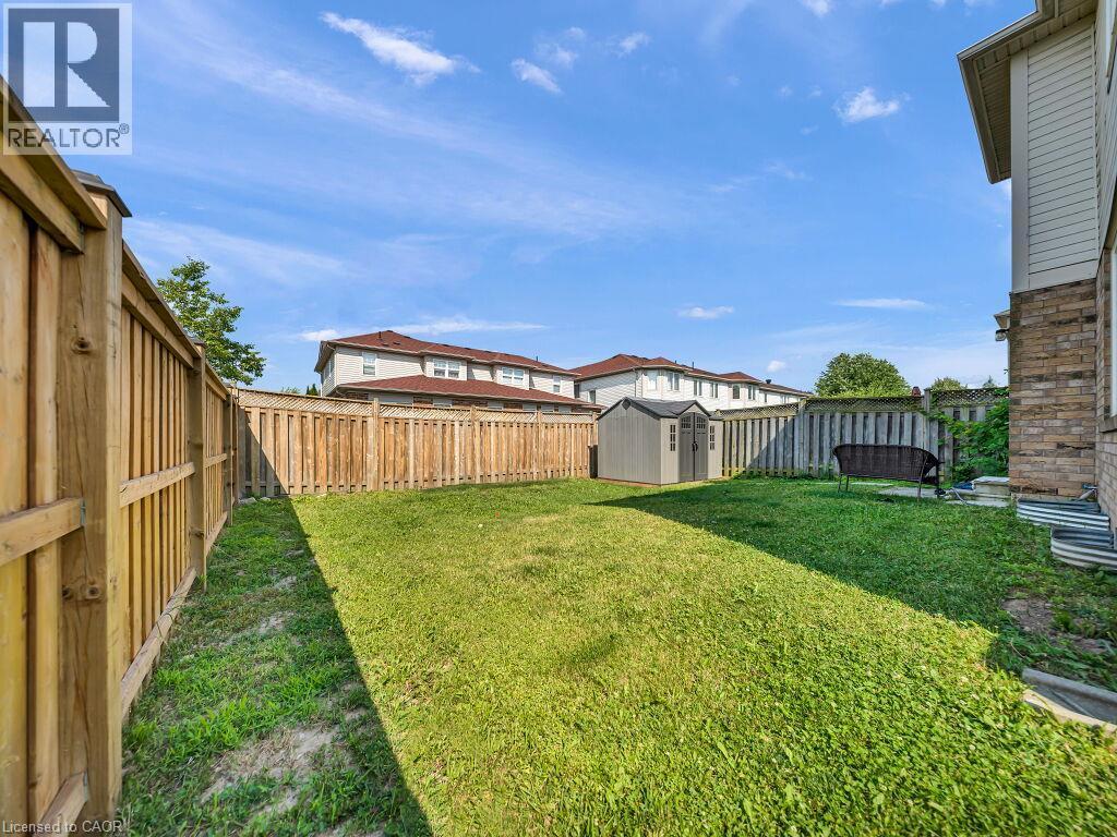 Private backyard featuring a wooden privacy fence, a storage shed, and a manicured lawn - 39 Baintree Way, Cambridge, ON - Outdoor