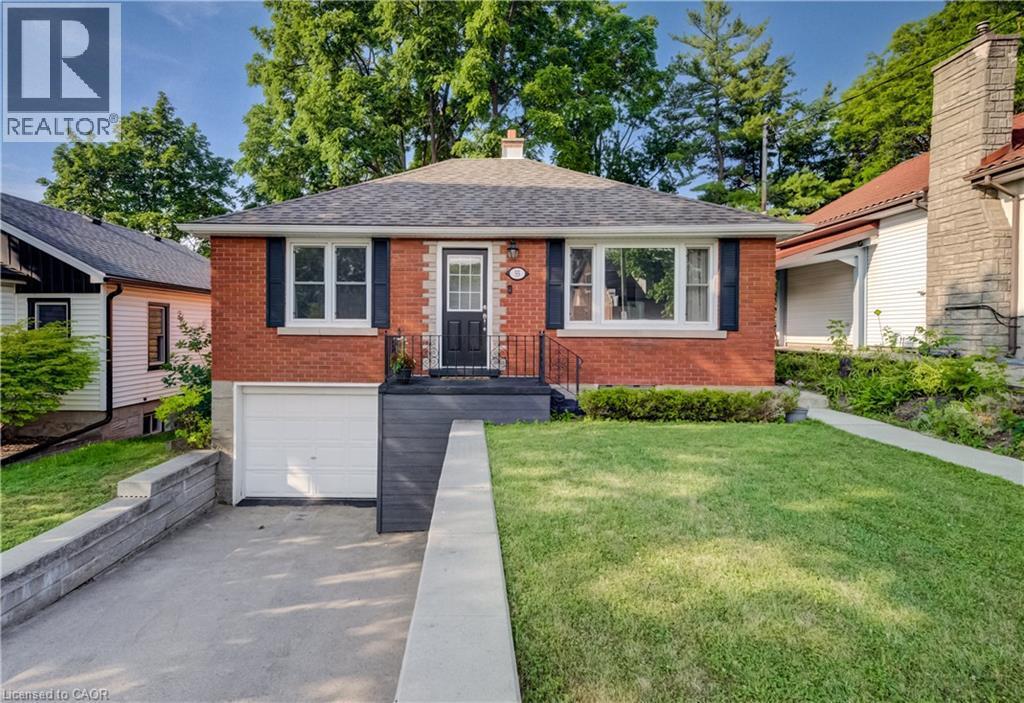 Red brick exterior featuring white window trim, dark shutters, and a covered entry - 55 Rex Drive, Kitchener, ON - Outdoor