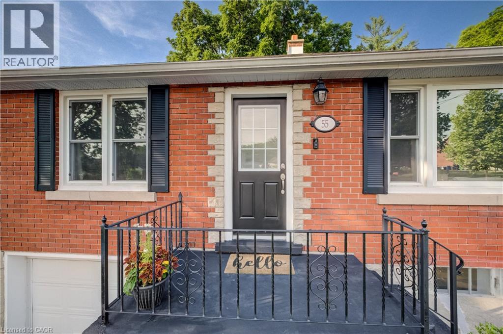Brick exterior featuring decorative stone accents, white window frames, black louvered shutters, and a black front door with an integrated glass panel - 55 Rex Drive, Kitchener, ON - Outdoor With Exterior