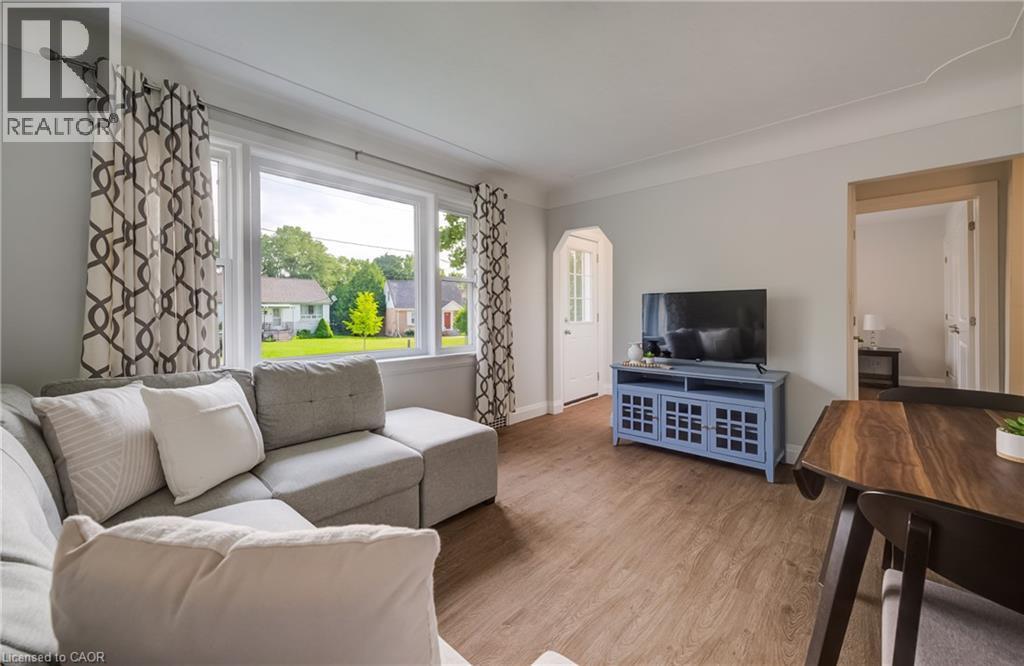 Living area featuring wood-finish flooring, light gray wall paint, and a large window - 55 Rex Drive, Kitchener, ON - Indoor Photo Showing Living Room