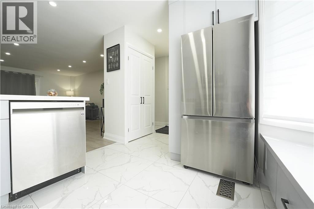 Kitchen featuring stainless steel appliances, white cabinetry, and white tile flooring - 136 Jansen Avenue, Kitchener, ON - Indoor