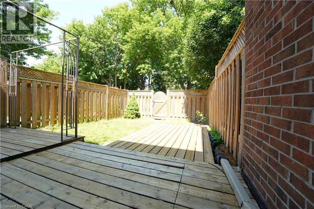 Expansive wood deck overlooking a fenced backyard with a grass lawn - 136 Jansen Avenue, Kitchener, ON - Outdoor