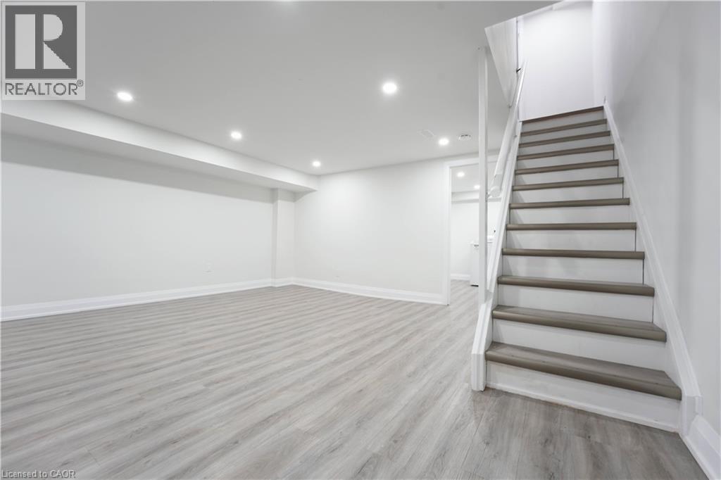 Spacious finished room featuring light wood-finish flooring, white painted walls, and recessed lighting - 136 Jansen Avenue, Kitchener, ON - Indoor Photo Showing Other Room