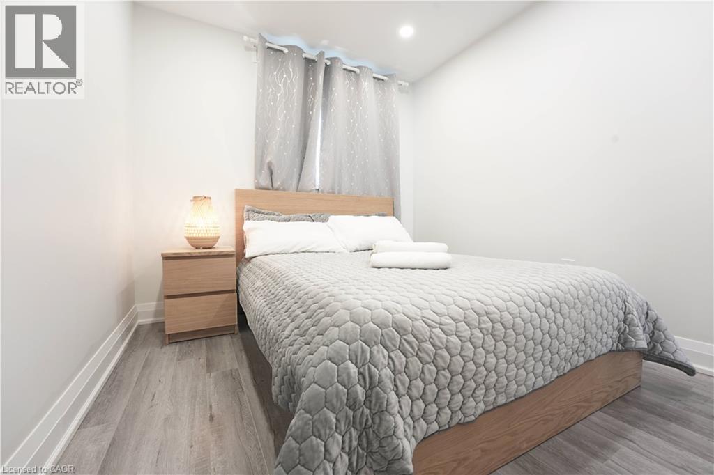 Wood-finish flooring with white baseboards - 136 Jansen Avenue, Kitchener, ON - Indoor Photo Showing Bedroom