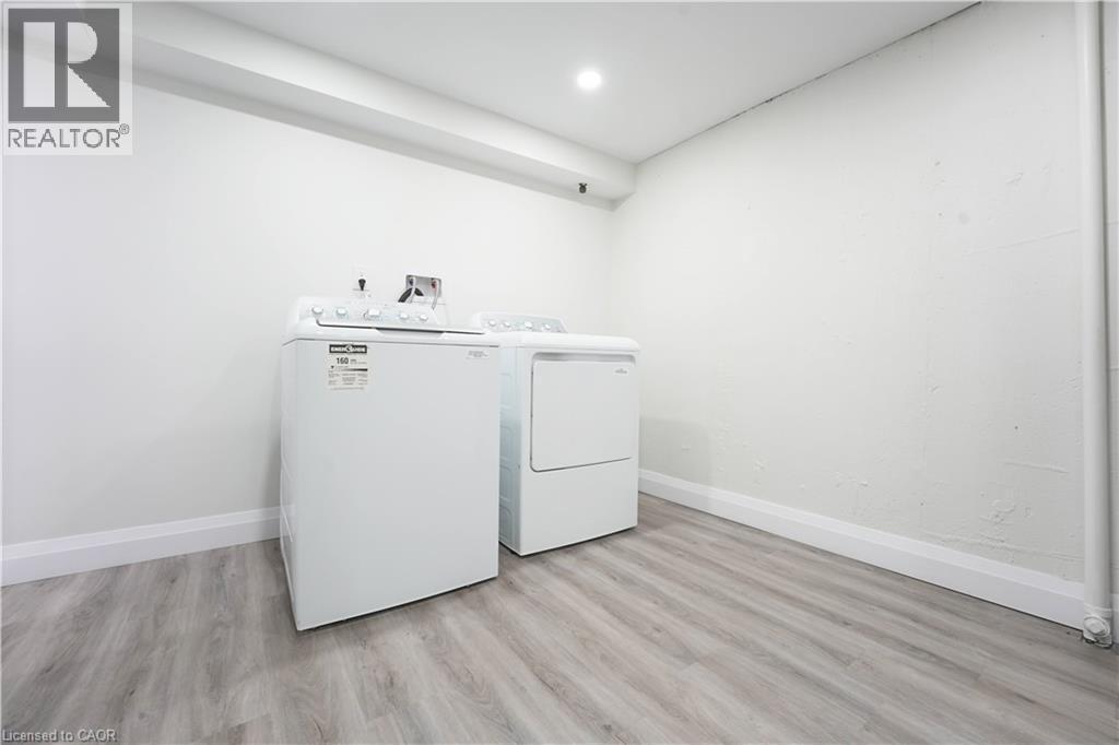 Dedicated laundry area with a top-load washing machine and front-load dryer - 136 Jansen Avenue, Kitchener, ON - Indoor Photo Showing Laundry Room