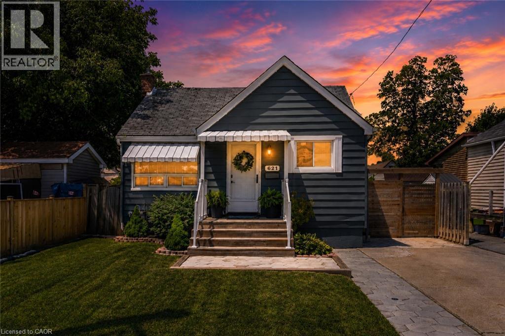 Charming bungalow exterior featuring horizontal siding and a prominent front entry with a white door - 621 Tate Avenue, Hamilton, ON - Outdoor